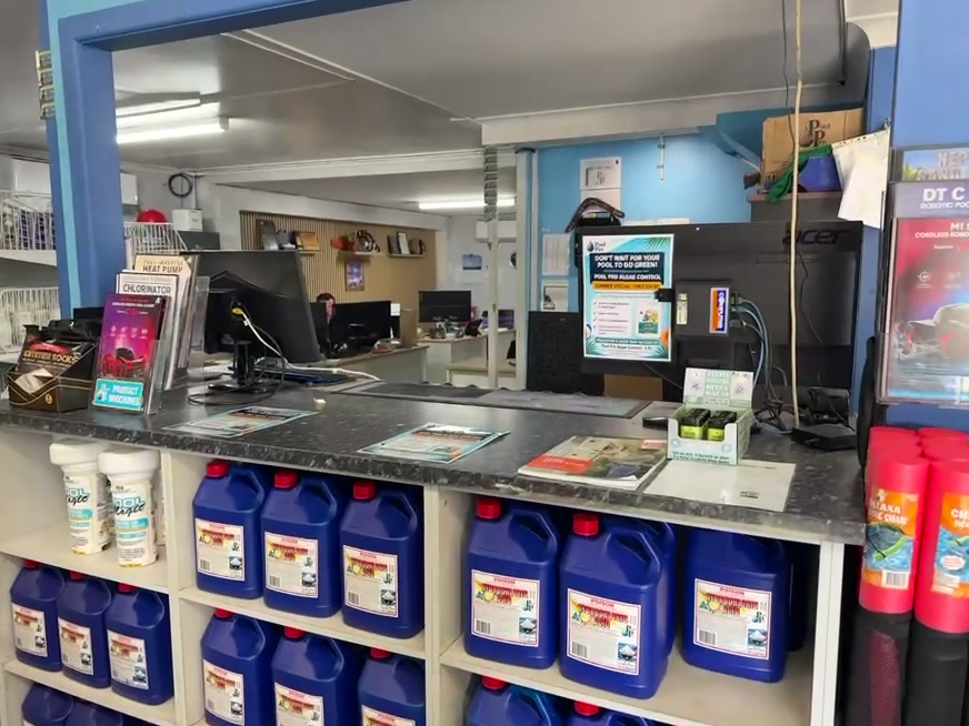 The service counter inside the shop, with chemicals racked underneath it.